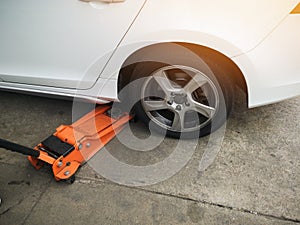 jacking up a car with the emergency jack for changing car tire