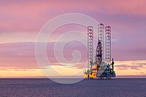 Jackup moveable oil platform at sunset in Gulf of Mexico photo