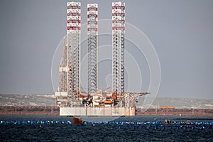Oil rig moored in harbor with legs lifted photo