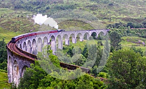 The Jacobite steam train, aka `Hogwarts Express in Harry Potter movies` passes Glenfinnan viaduct, Scotland, UK photo