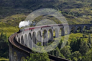 Jacobite steam train on Glenfinnan Viaduct approaching, Highlands, Scotland, UK