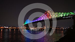 Jacques Cartier Bridge in a rainbow lighting at night. Montreal