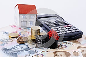 Jade black and coins stack with china banknote and paper house and calculator