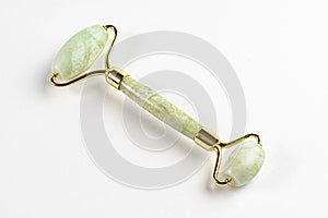 jade face roller massager in light green color isolated on white background