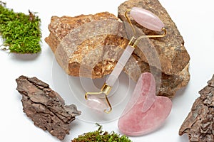 Jade roller and gua sha and stones on white background