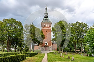 Old church made of bricks with lush green surrounding cemetery