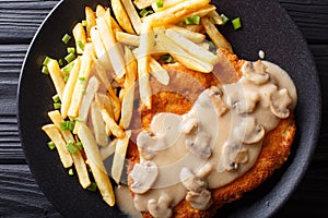 Jaeger Viennese schnitzel with French fries and mushrooms close-up. horizontal top view