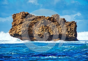 Jagged rock protruding from rough ocean water photo
