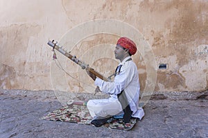 Musician play on traditional music instrument called Kamaycha for tourists on the road in Jaipur, Rajasthan, India