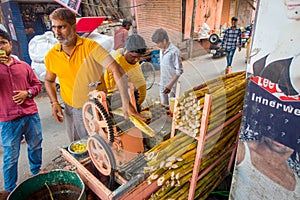 Jaipur, India - September 20, 2017: Unidentified man working with a machine to extract refreshing juice from sugar cane