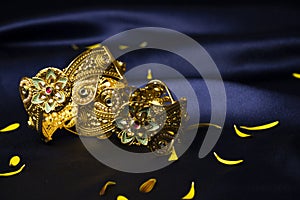 Jaipuri wide gold plated bangles on silk blue background wallpaper