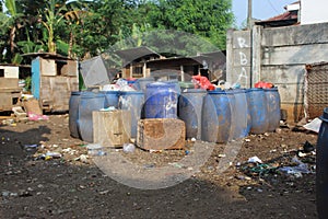 Jakarta, Indonesia - 06082020: Temporary residents` garbage shelter. Blue barrel to store trash. Trash clinic and household trash.