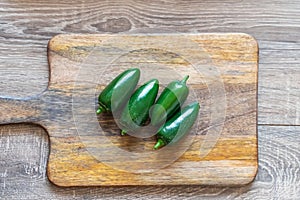 Jalapeno pepper green hot on a wooden cutting board top view
