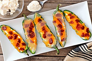 Jalapeno poppers with cheese and pepperoni on a white plate photo