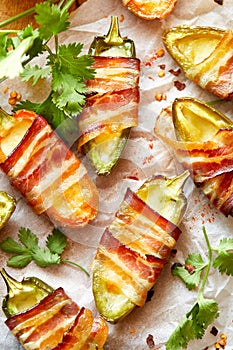 Jalapeno poppers wrapped in bacon stuffed with cheese seasoned with herbs and spices, delicious starter photo