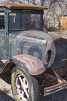 Jalopy car truck with front wheel, headlight, radiator, windshield shows another past era of transportation.