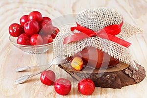Jam, confiture of Malpighia glabra (red acerola) in jar and fresh fruitsin bowl