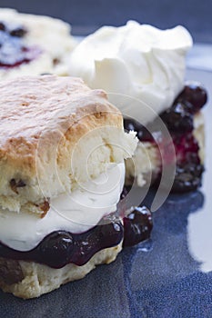 Jam and fresh cream scone on blue plate