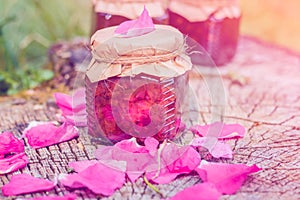 Jam from rose with rose petals on stump