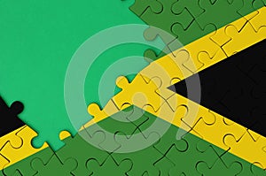 Jamaica flag is depicted on a completed jigsaw puzzle with free green copy space on the left side
