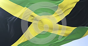 Jamaican flag waving at wind with blue sky in slow, loop