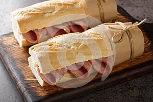 Jambon beurre is a simple and classic Parisian sandwich made with salted French butter and spiced ham closeup on the wooden board