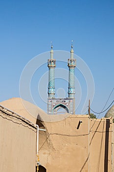 Jameh mosque, with its distinctive tiles minarets, seen from a nearby street. Jameh mosque is one of the symbols of Yazd