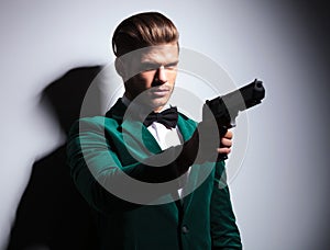 James Bond wannabe young assasin pointing his big pistol photo