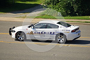 A police car stopped in the middle of the road to patrol the street