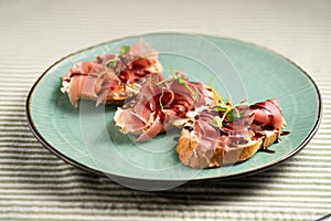 Jamon Iberico with white bread on blue plate