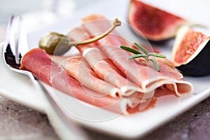 Jamon Serrano with caper berries and figs photo