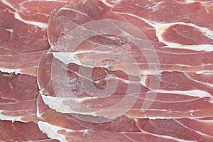 Jamon serrano. A Spanish ham texture background. Traditional spanish jamon sliced. Dry cured meat ham. Hamon iberico
