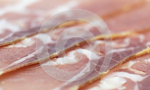 Jamon serrano. A Spanish ham texture background. Traditional spanish jamon sliced. Dry cured meat ham. Hamon iberico. Macro shot