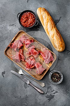 Jamon serrano. Traditional Spanish ham set, on gray stone table background, top view flat lay, with copy space for text