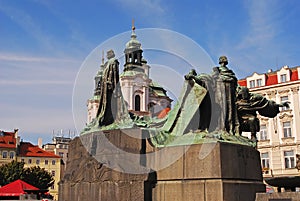 Jan Hus Memorial Statue with Saint Nicholas Church in the background photo