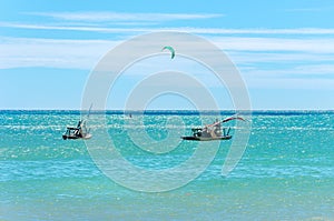 Jangada boat and kite surfers sailing together