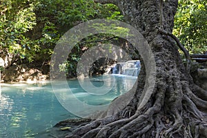 Jangle landscape with flowing turquoise water of Erawan cascade waterfall