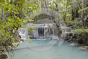 Jangle landscape with flowing turquoise water of Erawan cascade waterfall