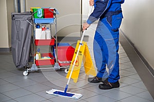 Janitor With Broom Cleaning Office Corridor photo