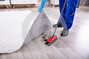 Janitor Cleaning Dirt Under The Carpet