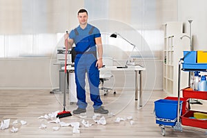 Janitor Cleaning Floor With Broom In Office