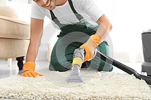 Janitor removing dirt from rug with carpet cleaner indoor