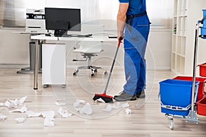 Janitor Sweeping Floor With Broom In Office