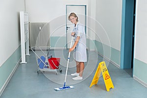 Janitor With Wet Caution Sign And Cleaning Equipments