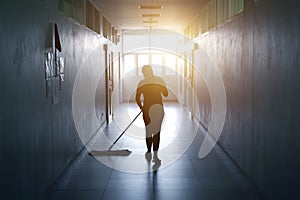 Janitor woman mopping floor in hallway office building