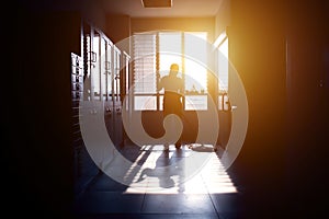 Janitor woman sillouette mopping floor in hallway office building