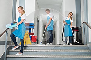 Janitors Cleaning Corridor With Cleaning Equipments photo