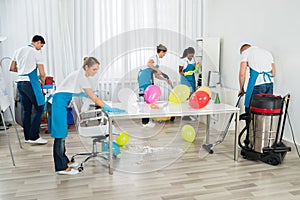 Janitors Cleaning The Office After Party