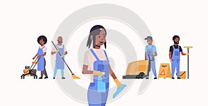 Janitors team working together cleaning service concept african american male female cleaners in uniform using