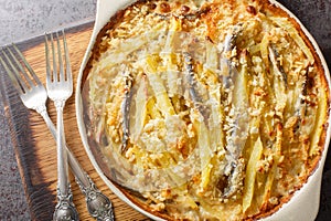 Jansson\'s frestelse or Janssons temptation is a Swedish gratin made from potatoes, onion and sprats closeup